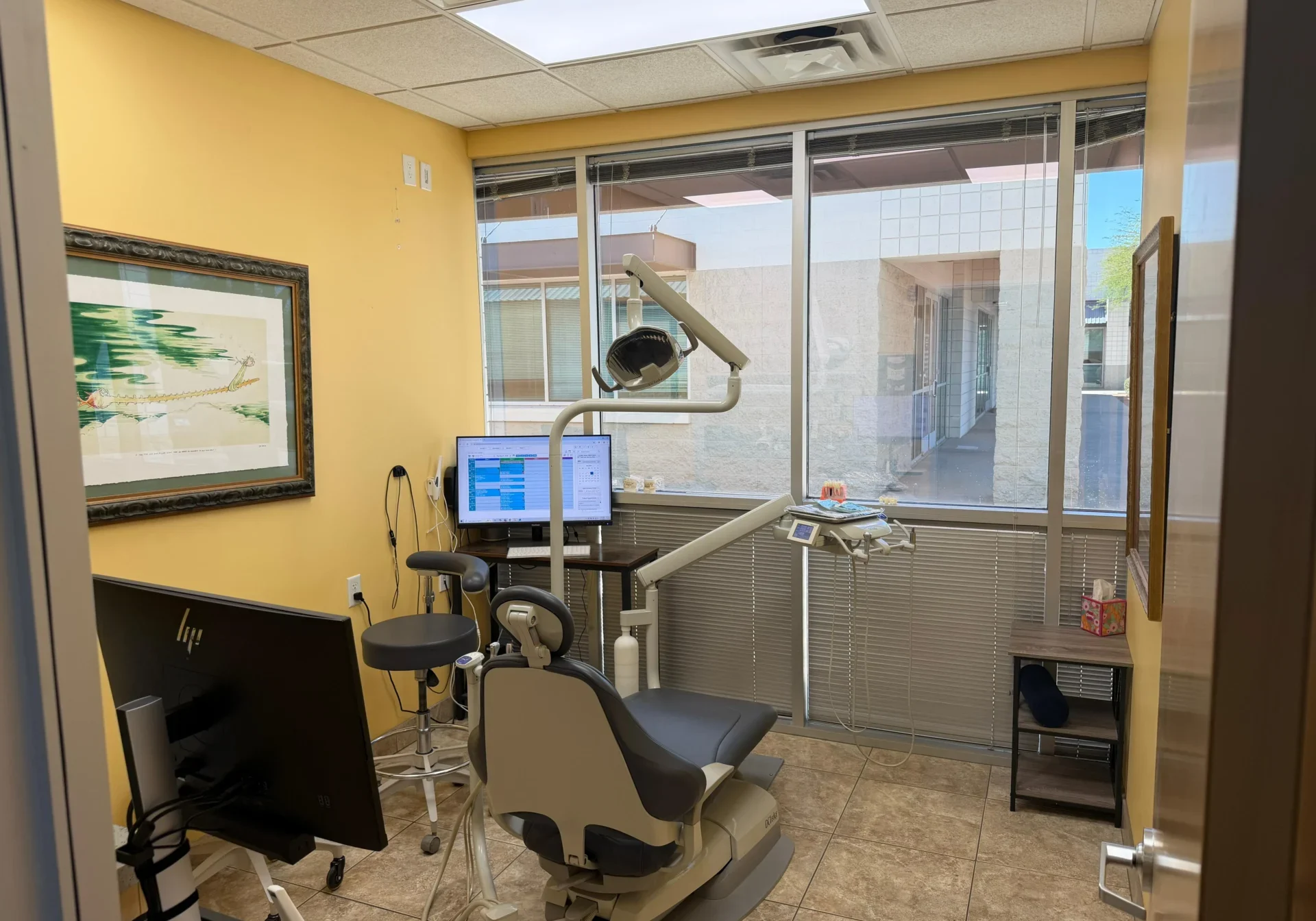 Modern dental treatment room at Arizona Crown Center located at 15288 Brookside Lane, Surprise, AZ 85374. Equipped with a dental chair, examination light, HP computer monitor, and digital imaging system for crown and bridge procedures.
